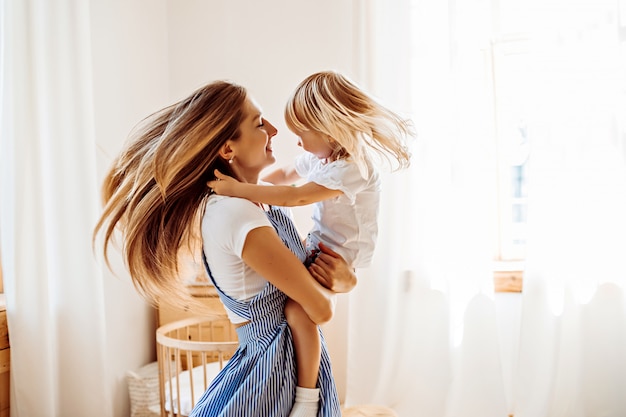 Giovane madre che gioca con il piccolo bambino a casa