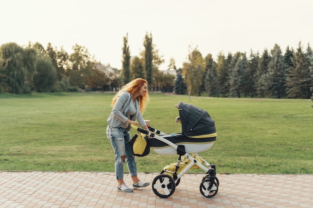 giovane madre che gode della passeggiata nel parco con il bambino