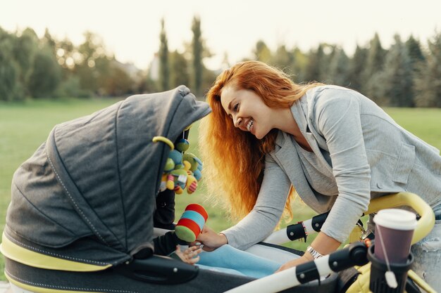 giovane madre che gode della passeggiata nel parco con il bambino