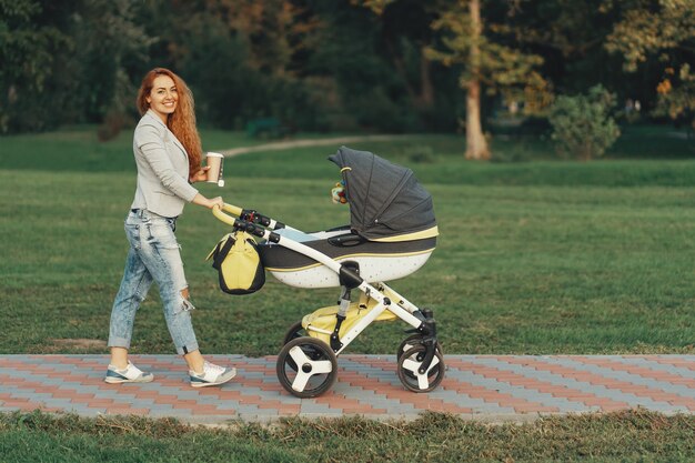 giovane madre che gode della passeggiata nel parco con il bambino