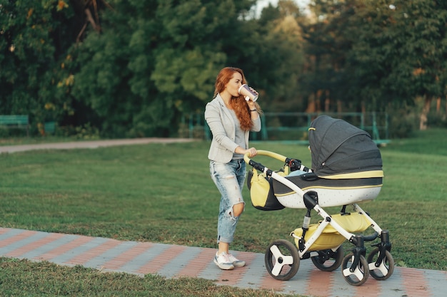 giovane madre che gode della passeggiata nel parco con il bambino