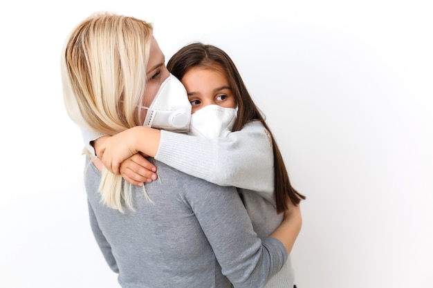 giovane madre che indossa una maschera protettiva PM2.5 per sua figlia. isolato su sfondo bianco.