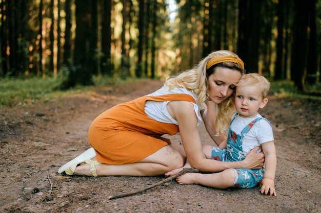 Giovane madre che si prende cura di suo figlio nella foresta