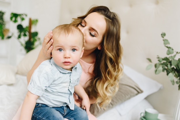 Giovane madre che tiene suo figlio carino tra le braccia. Famiglia, stare insieme.