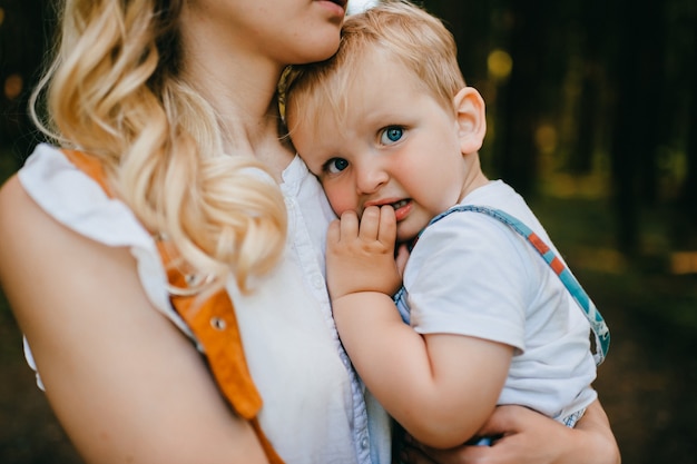 Giovane madre che tiene suo figlio nella foresta