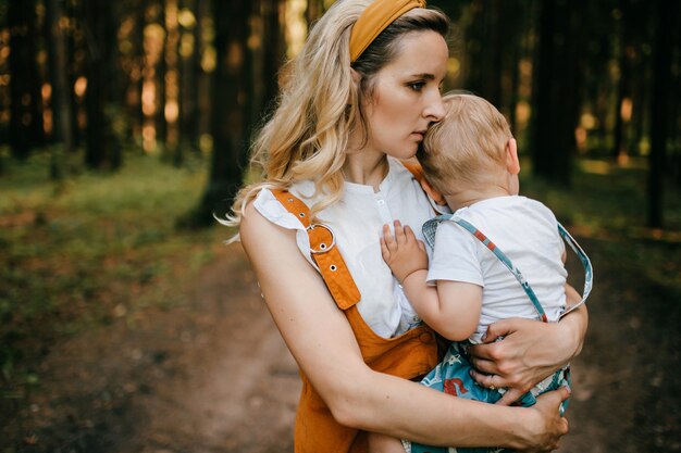 Giovane madre che tiene suo figlio nella foresta