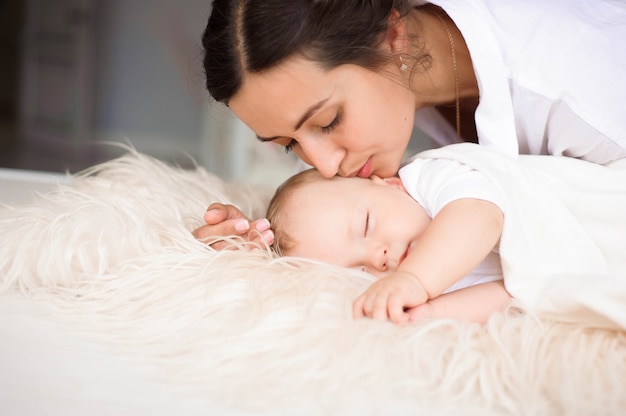 Giovane madre che tiene teneramente il suo bambino appena nato