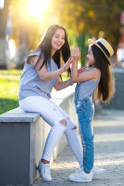 Giovane madre con figlia carina camminando per la strada