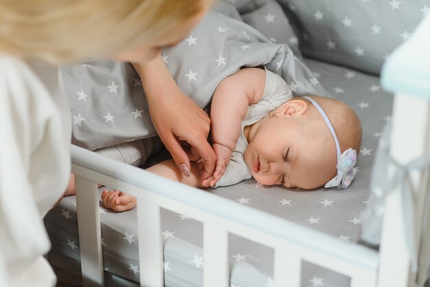 Giovane madre con il loro neonato vicino alla culla