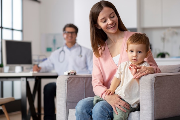 Giovane madre con il suo bambino dal pediatra per un esame fisico