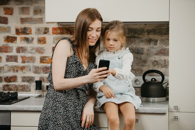 Giovane madre con la figlia carina in cucina