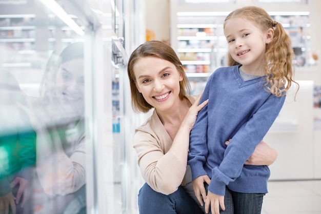 Giovane madre con la figlia che fa shopping in una farmacia
