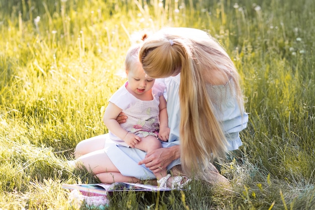 Giovane madre con la figlia del bambino nel parco di estate