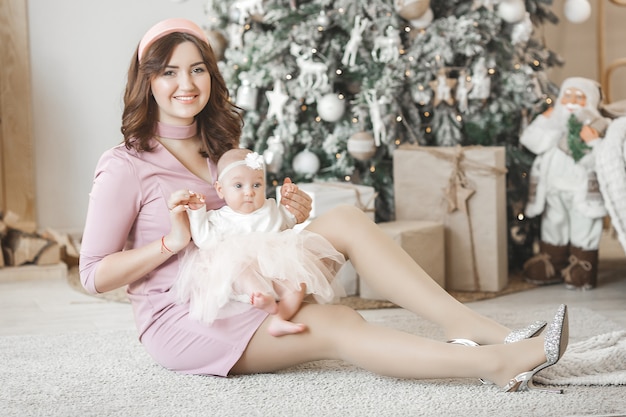 giovane madre con la sua piccola bambina con decorazioni natalizie