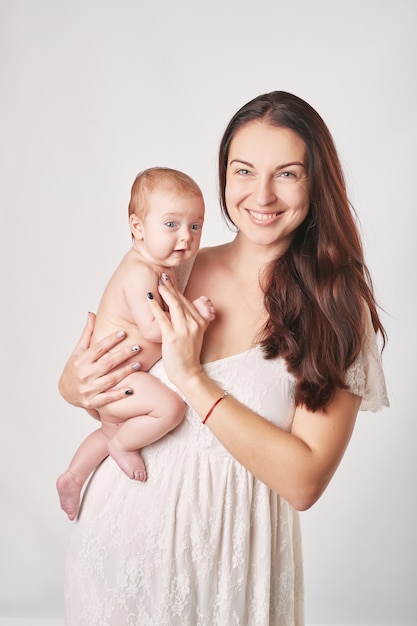 giovane madre con trucco naturale tiene il bambino tra le braccia