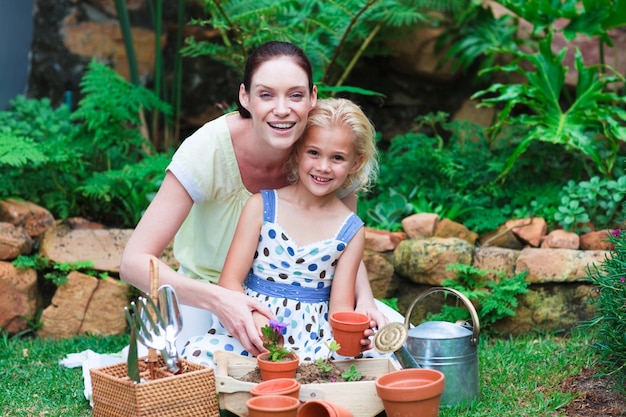 Giovane madre e figlia che piantano i fiori