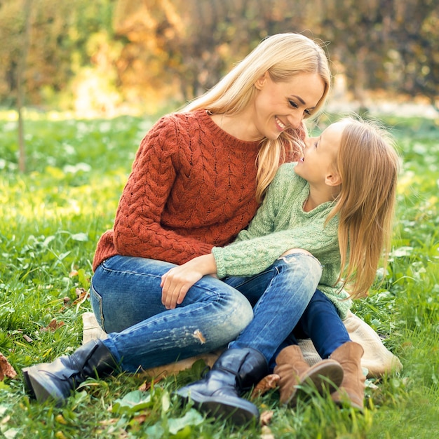 Giovane madre e figlia che si abbracciano all'aperto.