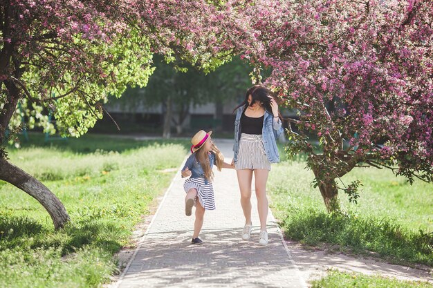 Giovane madre e la sua piccola figlia divertirsi insieme all'aperto