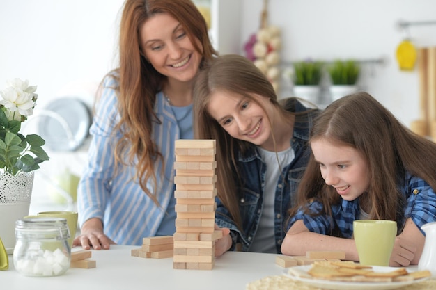 Giovane madre e le sue figlie che giocano con i blocchi di legno