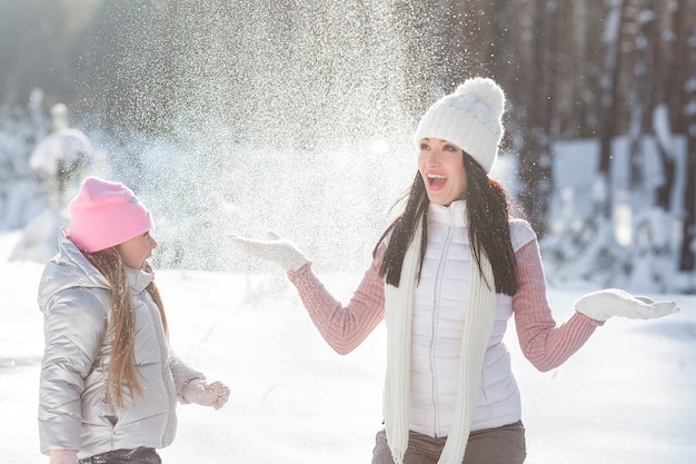 Giovane madre e sua figlia divertirsi nella neve