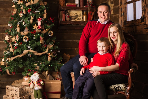 Giovane madre incinta, padre e figlio piccolo festeggiano il Natale a casa