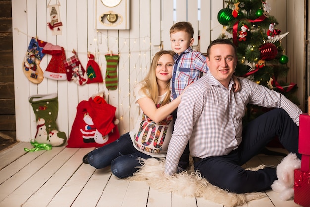 Giovane madre incinta, padre e figlio piccolo festeggiano il Natale a casa