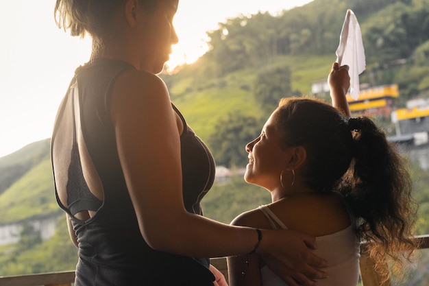 Giovane madre latina che guarda con orgoglio sua figlia mentre celebrano la loro libertà