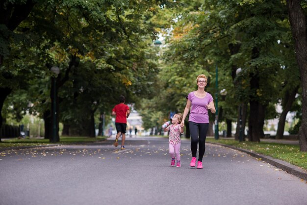 giovane madre sportiva e figlia piccola che fanno jogging in un parco cittadino sport all'aria aperta e fitness