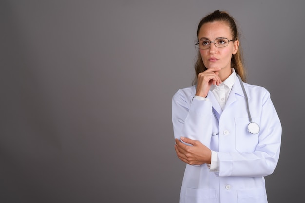 Giovane medico bella donna su sfondo grigio