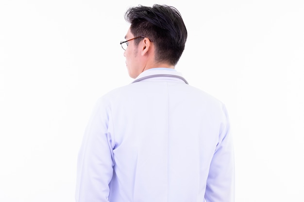giovane medico bello uomo asiatico con gli occhiali isolati contro il muro bianco