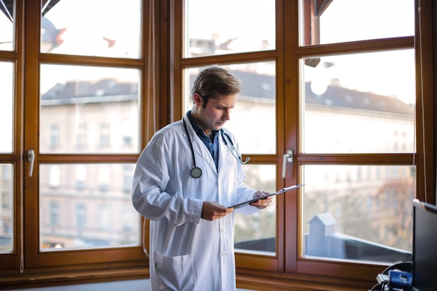 Giovane medico che legge un documento