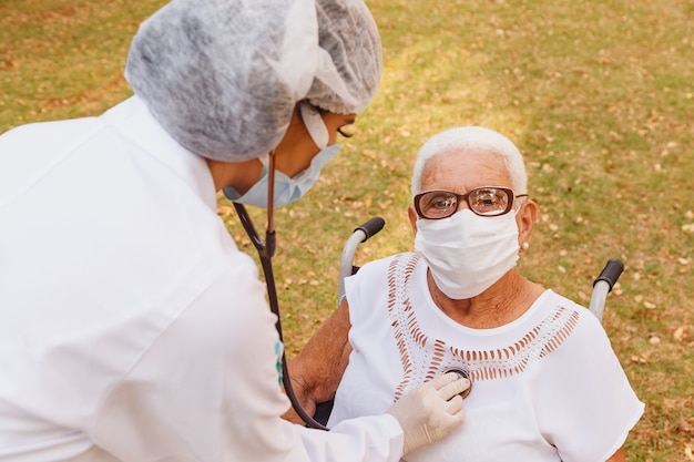 Giovane medico che si prende cura di una donna anziana nel parco