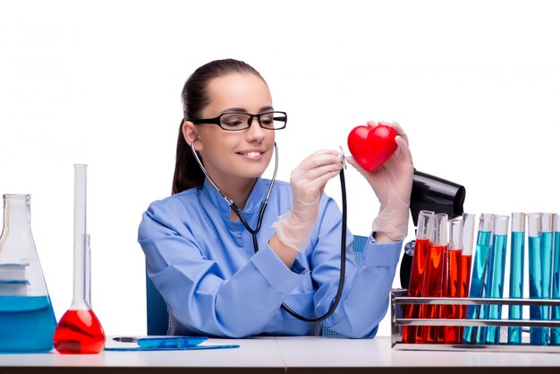 Giovane medico con cuore rosso isolato su bianco