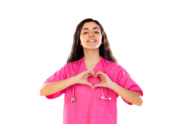 Giovane medico con l'uniforme rosa isolato su un muro bianco