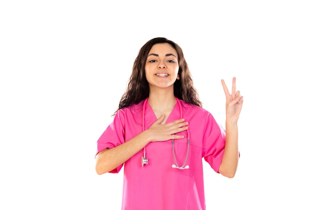 Giovane medico con l'uniforme rosa isolato su un muro bianco