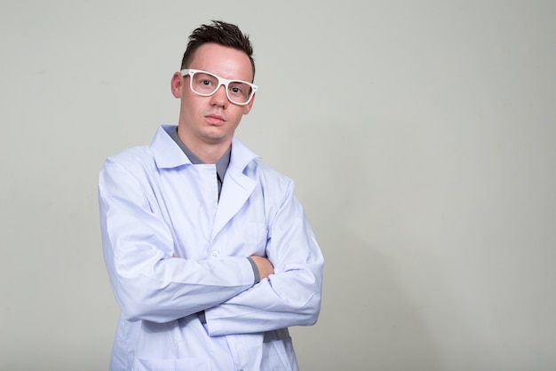 giovane medico con occhiali da vista contro lo spazio bianco