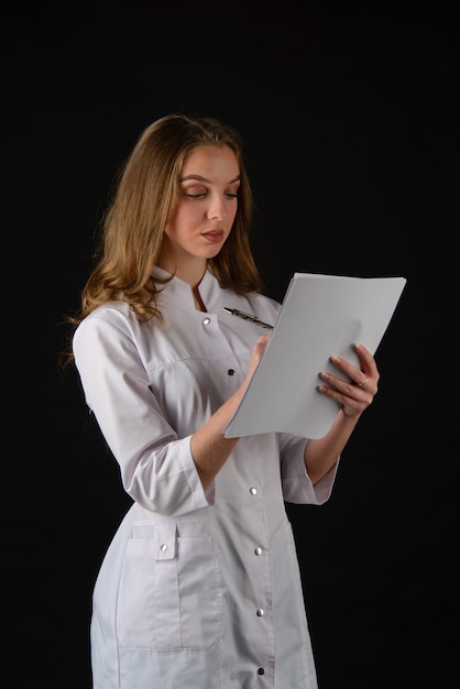 Giovane medico femminile attraente sul nero