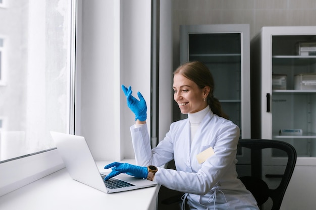 Giovane medico femminile che parla al paziente in linea dall'ufficio medico