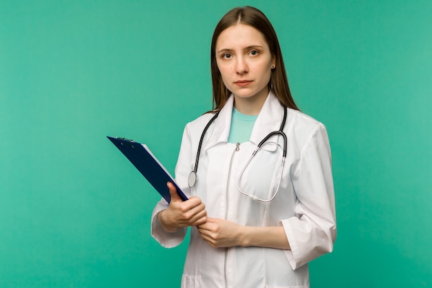 Giovane medico femminile sorridente felice con i appunti