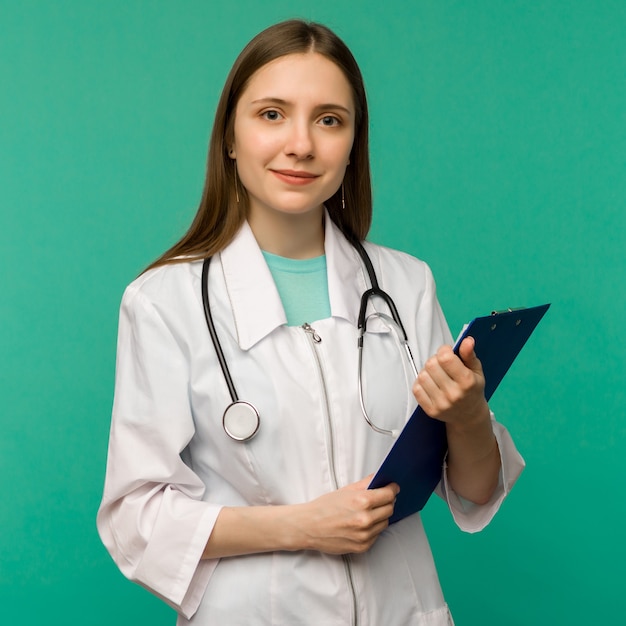 Giovane medico femminile sorridente felice con i appunti