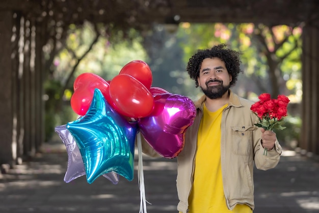 Giovane messicano con palloncini e fiori il giorno di san valentino