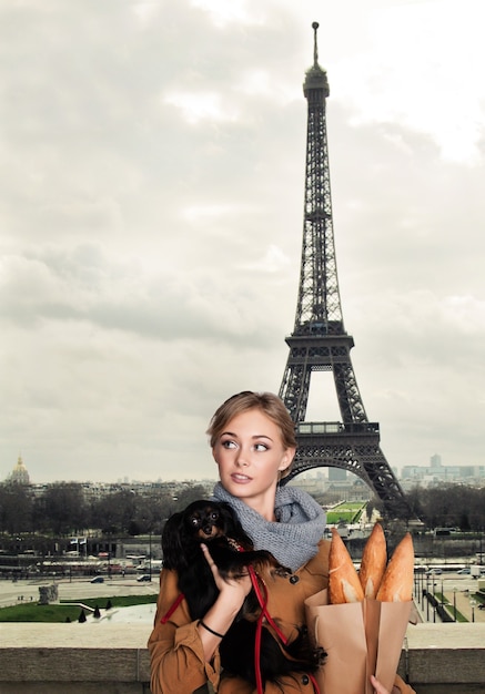 Giovane modella donna con cane di piccola taglia a Parigi, Francia