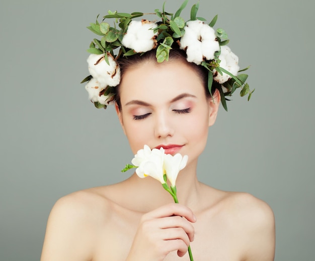 Giovane modello femminile con pelle sana e fiori di cotone bianco Concetto di cura della pelle e aromaterapia