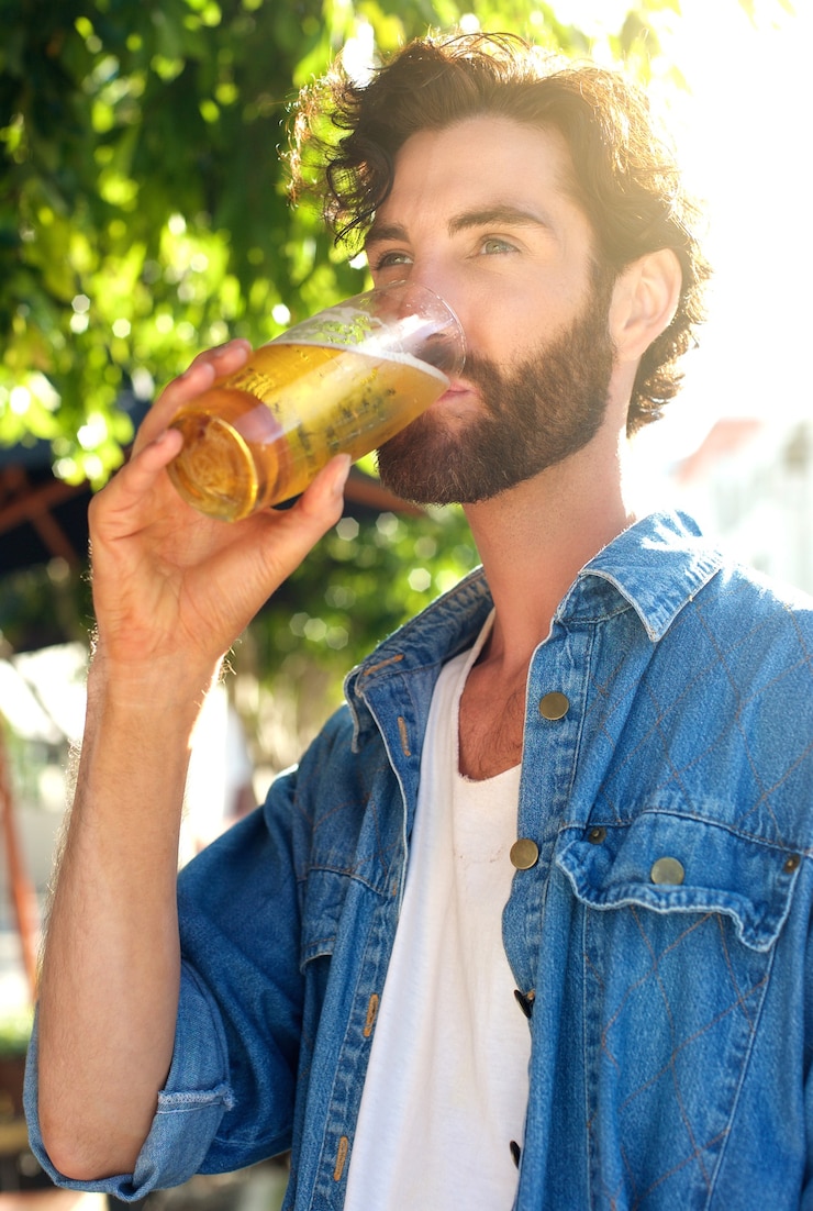 Foto giovane moderno che beve birra in estate al bar all&#39;aperto