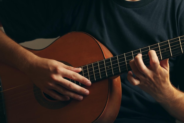 Giovane musicista che suona la chitarra acustica da vicino