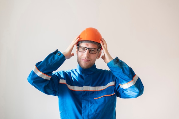 Giovane operaio maschio che tiene un casco, attrezzatura di sicurezza industriale