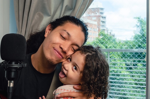 giovane padre che dà affetto a sua figlia dopo aver cantato una canzone