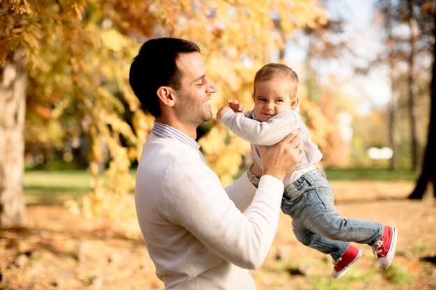 Giovane padre e neonato nel parco d&#39;autunno