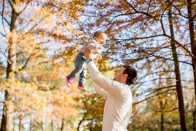 Giovane padre e neonato nel parco d&#39;autunno