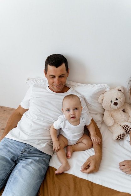 giovane papà sul letto con un bambino